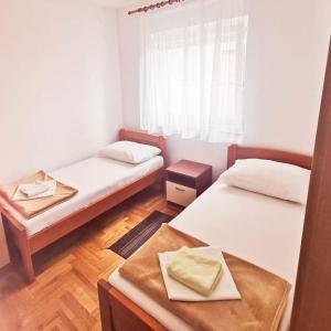 um pequeno quarto com 2 camas e uma janela em Apartments Jadranka em Zadar