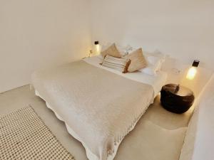 a bedroom with a large bed with white sheets and pillows at Boutique Hotel Jardines de Palerm in San Jose