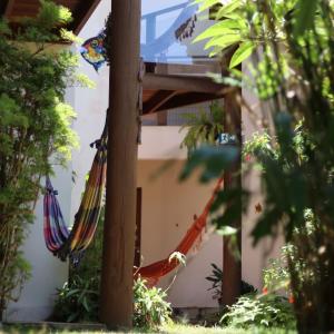 a couple of hammocks sitting next to a building at Albacora Eco Residence in Imbassai