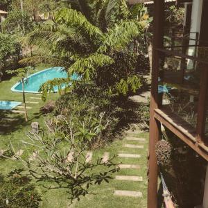 uitzicht op een tuin met een zwembad bij Albacora Eco Residence in Imbassai