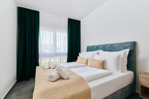 um quarto com uma grande cama branca e uma janela em Apartments San Maris em Umag