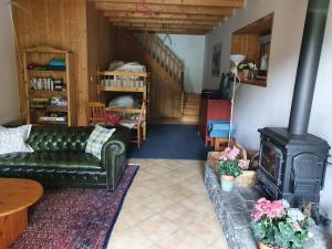 Chalet Liberte في سان جان دو أولبس: غرفة معيشة مع أريكة وموقد خشبي