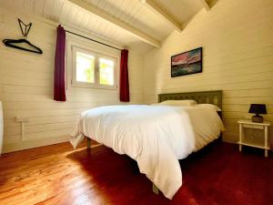 a bedroom with a bed with white sheets and a window at Willow Lodge in Buckhorn Weston