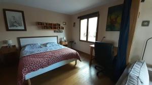 Schlafzimmer mit einem Bett, einem Fenster und einem TV in der Unterkunft L'appel de la foret in Rocroi