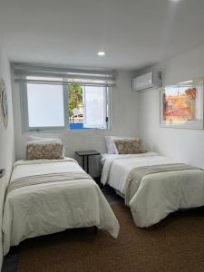 two beds in a room with two windows at Janer House at San Juan in San Juan