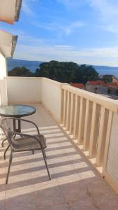 a patio with a table and a chair on a balcony at Apartments Duce (122) in Duće