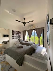 una camera da letto con due letti e un ventilatore a soffitto di LamanLeman Langkawi a Pantai Cenang