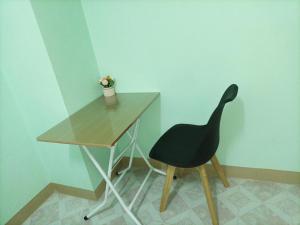 a black chair sitting next to a wooden desk at JATUPORN A2 in Ban Talat Rangsit
