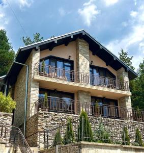 a large house with a balcony on top of it at Rodopski Ailyak in Dospat