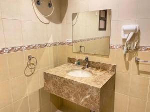 a bathroom with a sink and a mirror and a phone at Al Diyafa Serviced Apartments in Al Ahsa +40 photos