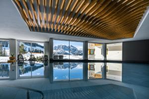 a swimming pool in a house with a view of the mountains at Hotel Costes in Corvara in Badia