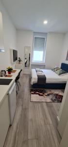 ein kleines Schlafzimmer mit einem Bett und einer Küche in der Unterkunft Mika Apartment and Studios in Zagreb