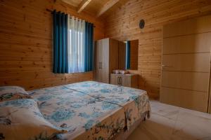 a bedroom with a bed in a wooden room at The Sea House Velipoje in Velipojë