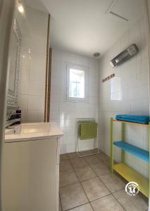 La salle de bains est pourvue d'un lavabo, d'une baignoire et d'une fenêtre. dans l'établissement Le Cèdre du Parc de la Dame, à Latour-Bas-Elne