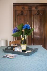a bottle of wine and a vase of flowers on a table at Eco-Gîte La Métairie Saint-Michel de Quinipily By KEROUZEC in Baud