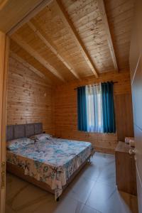a bedroom with a bed in a wooden room at The Sea House Velipoje in Velipojë