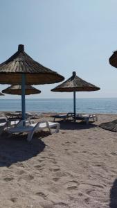 eine Gruppe von Sonnenschirmen und Stühlen am Strand in der Unterkunft Blaxy Resort STEFI in 23 August