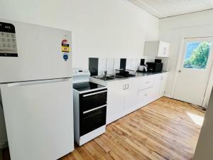 a kitchen with white appliances and a wooden floor at Talbingo Lodge - Selwyn Accommodation in Talbingo