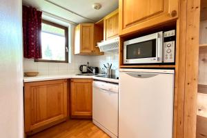 una cucina con frigorifero bianco e forno a microonde di Bright 50 m cocoon with balcony in Combloux a Combloux