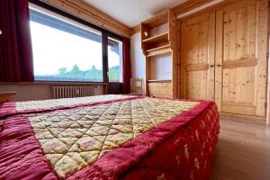 sypialnia z łóżkiem i dużym oknem w obiekcie Bright 50 m cocoon with balcony in Combloux w mieście Combloux