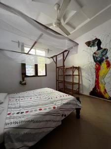 a bedroom with a bed and a painting on the wall at Wakanda Nungwi in Nungwi