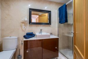 a bathroom with a sink and a toilet and a mirror at Apartamento La orilla in Arrecife +11 photos