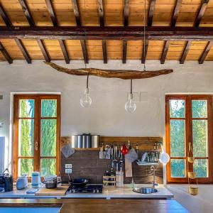 cocina con 2 ventanas y encimera en Country Loft at Palazzo di Bagnaia, en Castel del Piano
