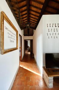 a hallway with a television and a wall with a picture at Country Loft at Palazzo di Bagnaia in Castel del Piano