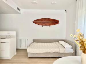 a bedroom with a bed with a surfboard on the wall at Sa Conca in S'agaro