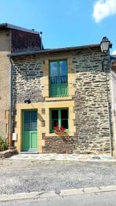 Gite de la semoy في Haulmé: مبنى حجري بأبواب خضراء ونافذة