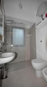 un bagno bianco con lavandino e WC di B&B Casa Soresina a Offagna Altre 65 foto