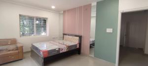 um quarto com uma cama, uma janela e um espelho em B S Homes em Hyderabad