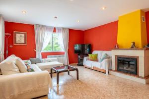 a living room with red walls and a fireplace at Luna Azul in Sant Jordi