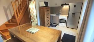 a kitchen with a wooden table and a refrigerator at Le gÎte d'aglaÉ in Chémery