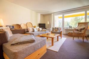 a living room with a couch and a table at Rothornblick 19 in Arosa