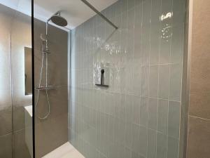 uma casa de banho com um chuveiro e uma porta de vidro em Sa Conca em S'agaró