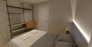 a small bedroom with a bed and a closet at Apartamento Metalic com lareira ecológica in Bento Gonçalves