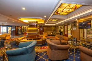 a hotel lobby with couches chairs and a television at Grand Anka Hotel in Istanbul