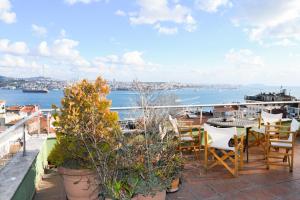 balkon ze stołem i krzesłami oraz widokiem na wodę w obiekcie Wonder Homes- Spectacular View 6BR, 2BA, Rooftop w Stambule