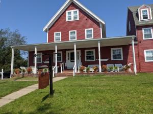 a red house with a sign in front of it at Surfside Inn Chatham in Chatham