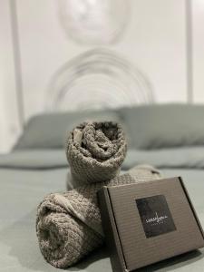 a book sitting on a bed with a towel at LamanLeman Langkawi in Pantai Cenang