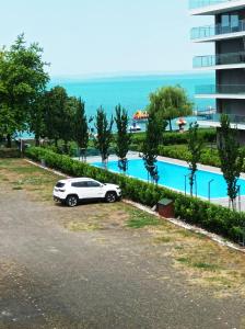 a white car parked next to a swimming pool at Sunrise Apartman in Siófok