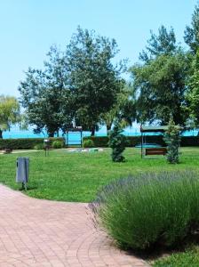 a park with a bench and trees and grass at Sunrise Apartman in Siófok