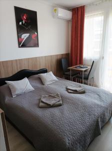 a bedroom with a bed with two towels on it at Sunrise Apartman in Siófok