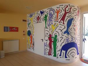 a room with a wall covered in graffiti at Eliopoli Beach Hostel & Restaurant in Tirrenia