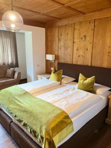 a large bed in a room with wooden walls at Ciasa Agreiter in La Villa