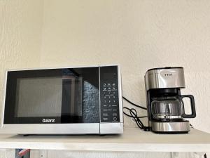 a microwave sitting on a shelf next to a coffee maker at Rosa1B in Mexico City