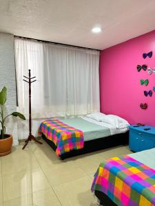 a bedroom with two beds and a cross on the wall at Rosa1B in Mexico City