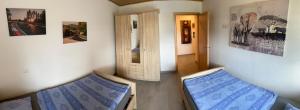 una habitación con 2 camas y una puerta con fotos en Alte Tankstelle, en Straßenhaus