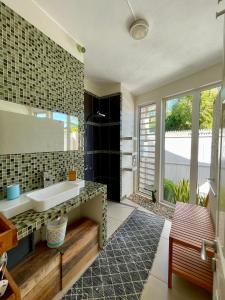 uma casa de banho com um lavatório e uma grande janela em Villas Hibiscus em La Gaulette